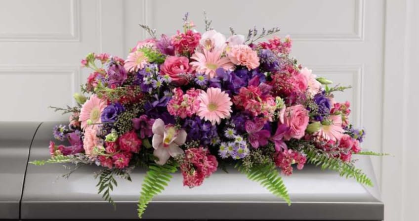 Pink and purple floral casket spray with mixed blooms