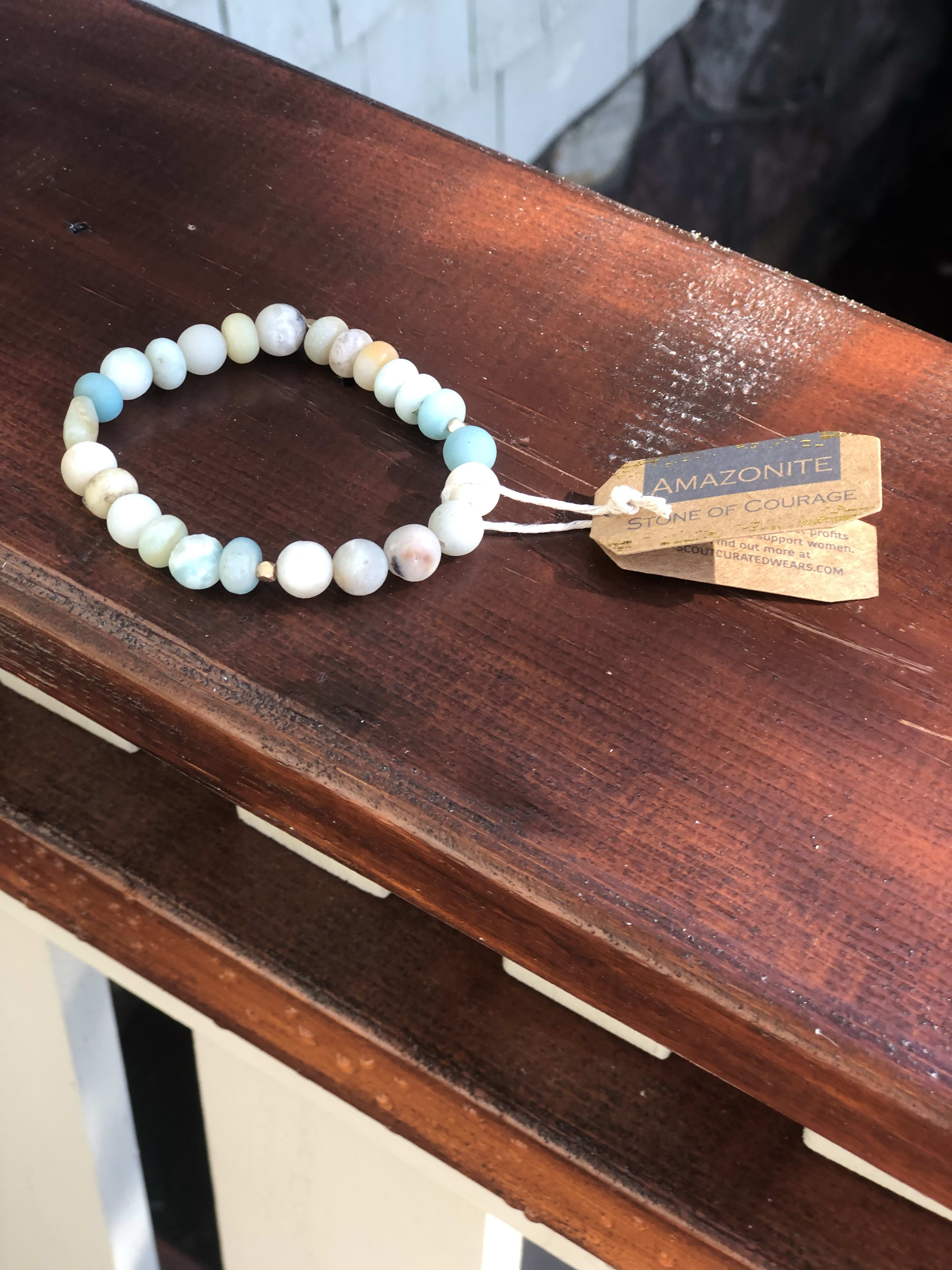Beaded bracelet with pale blue and white stones on a wooden surface