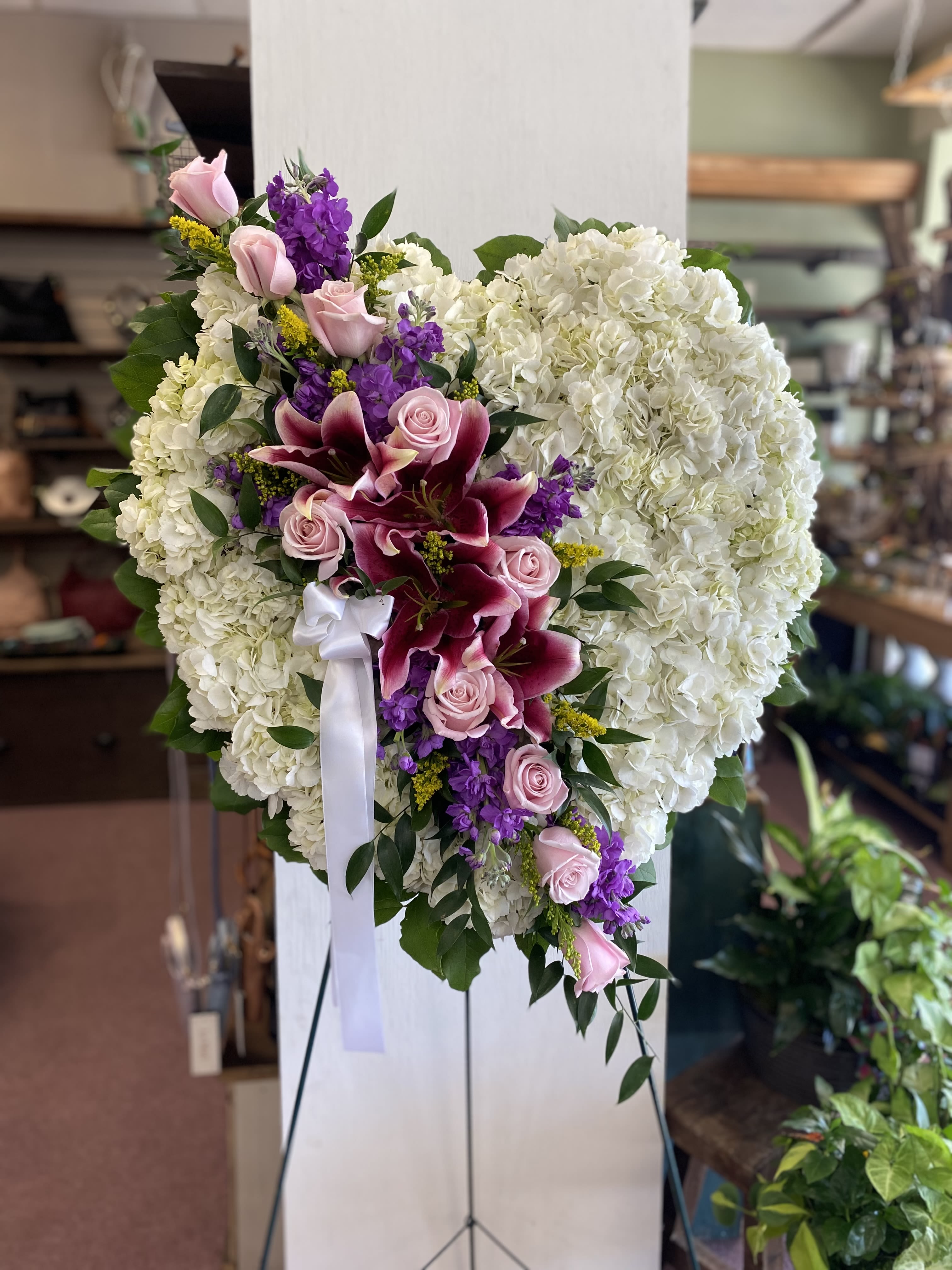 Heart-shaped floral spray with white hydrangeas, pink roses, and purple lilies