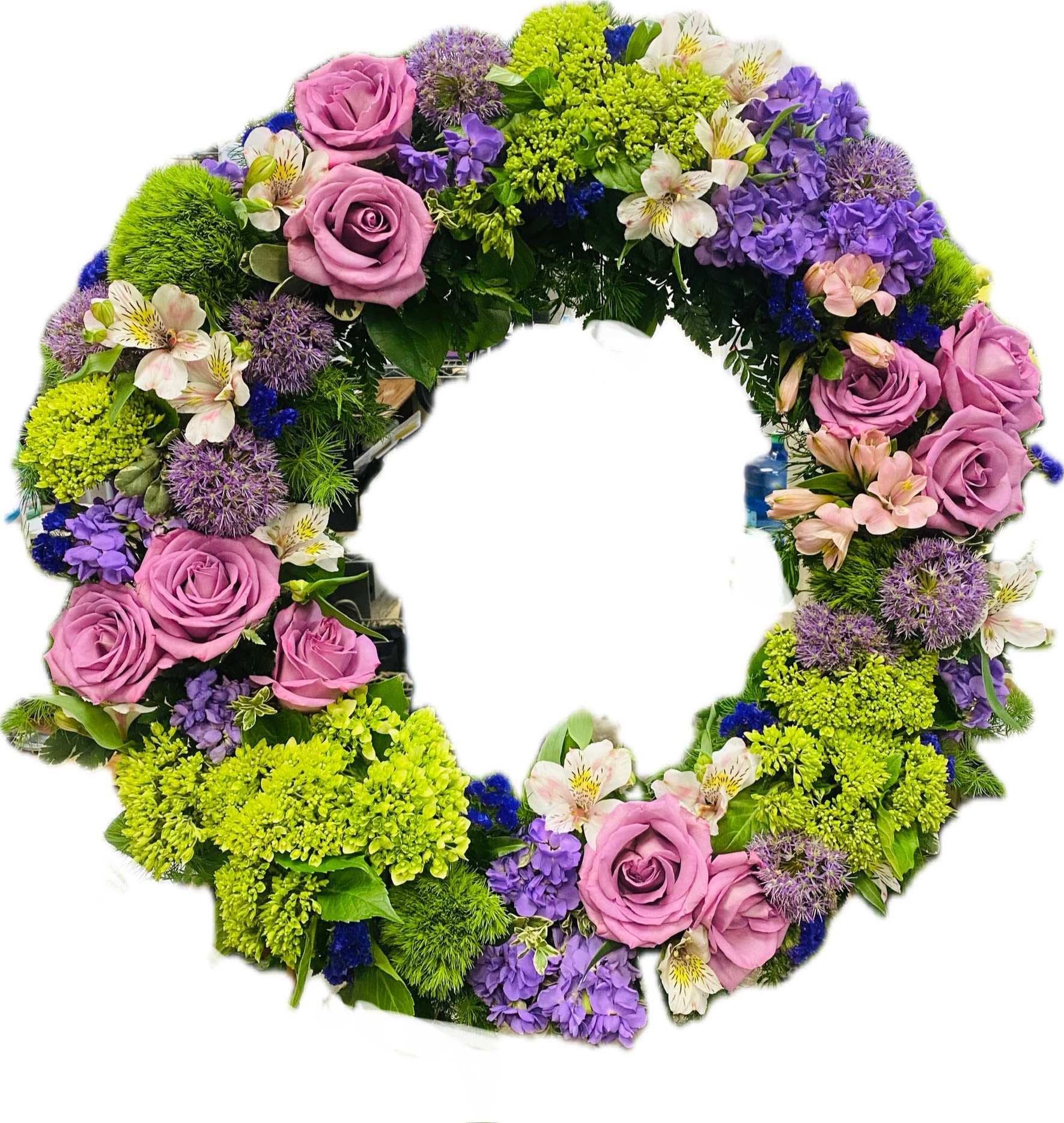 Circular floral wreath with pink roses, purple blooms, and bright green flowers
