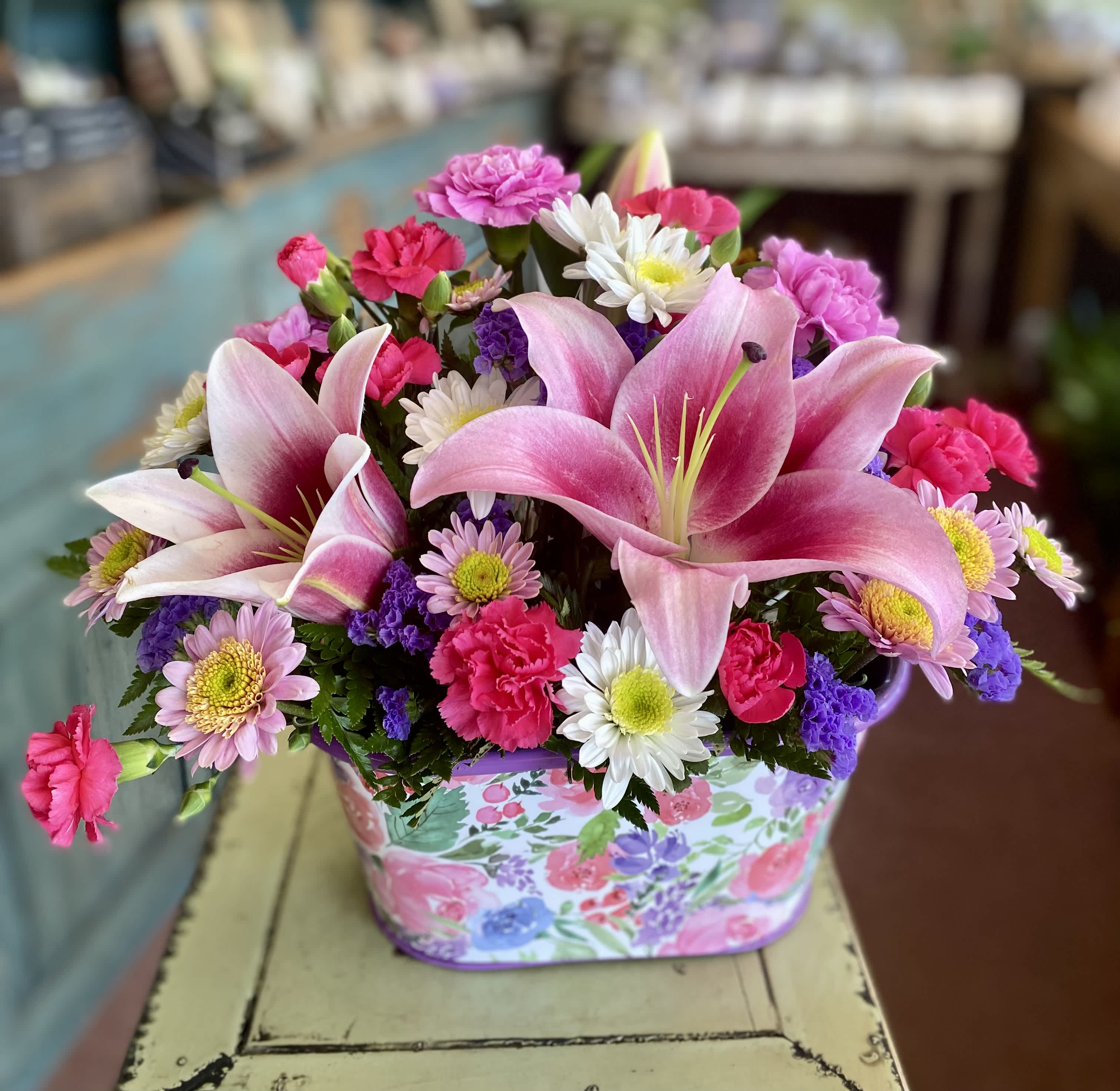 Pink lilies and mixed daisies in a floral gift box
