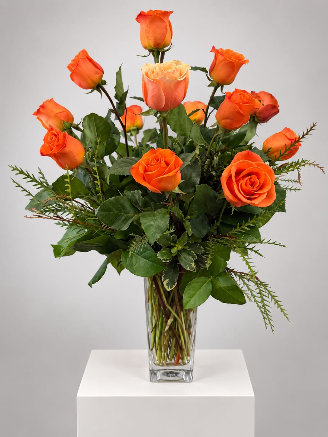 Orange roses arranged in a clear glass vase