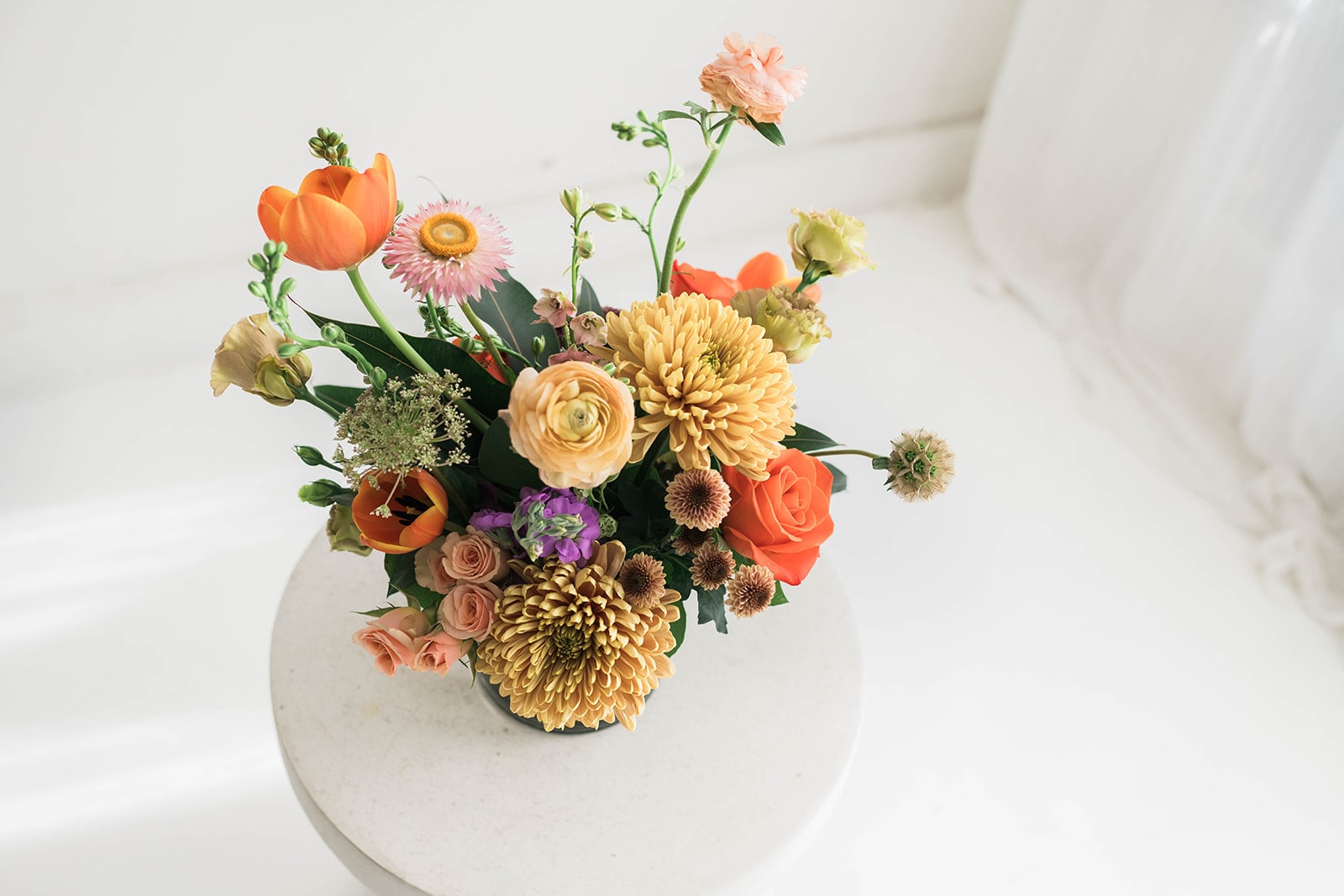 Bright &amp; Earthy Petite Designer's Choice - Lovey mix of bright blooms. This is a petite arrangement of approximately 10" tall.