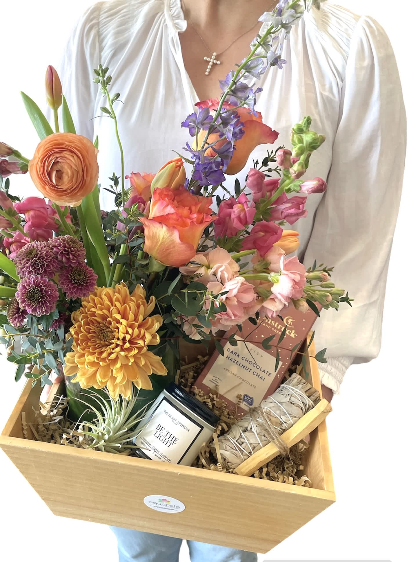 Mixed flower gift basket with candles and chocolate in a wooden crate