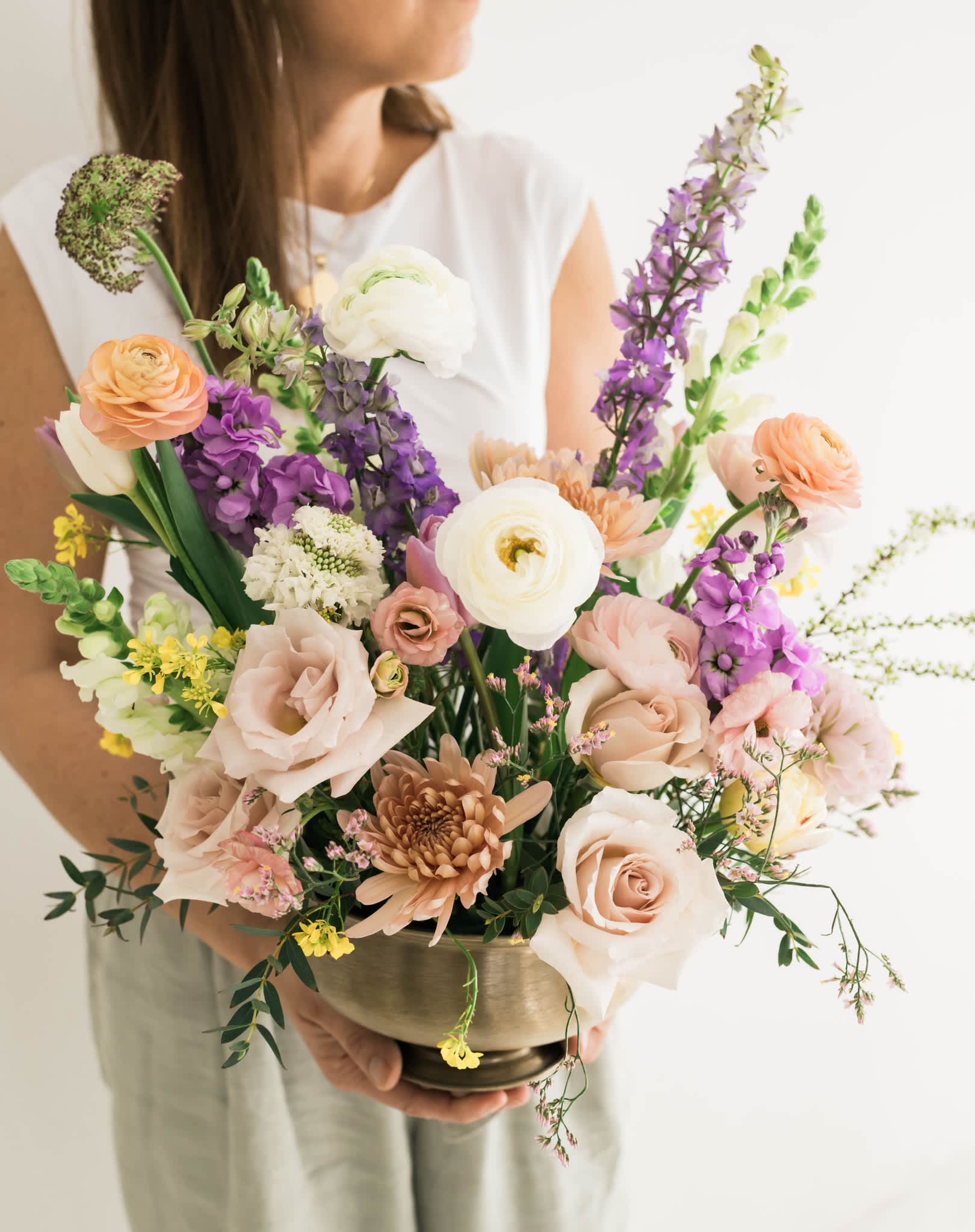 Mixed bouquet in a brass bowl with peach, white, and purple flowers