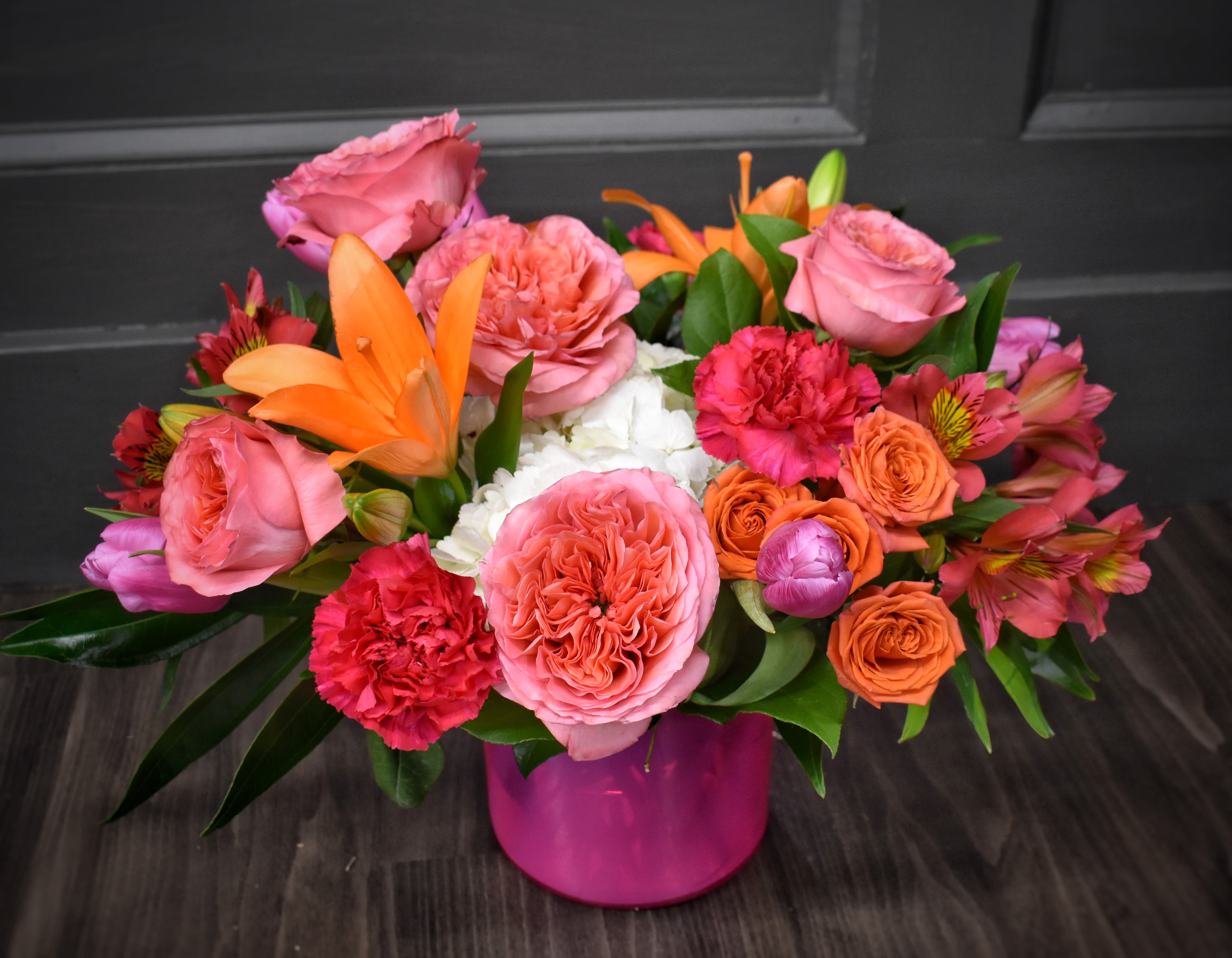 Pink and orange mixed bouquet in a magenta vase