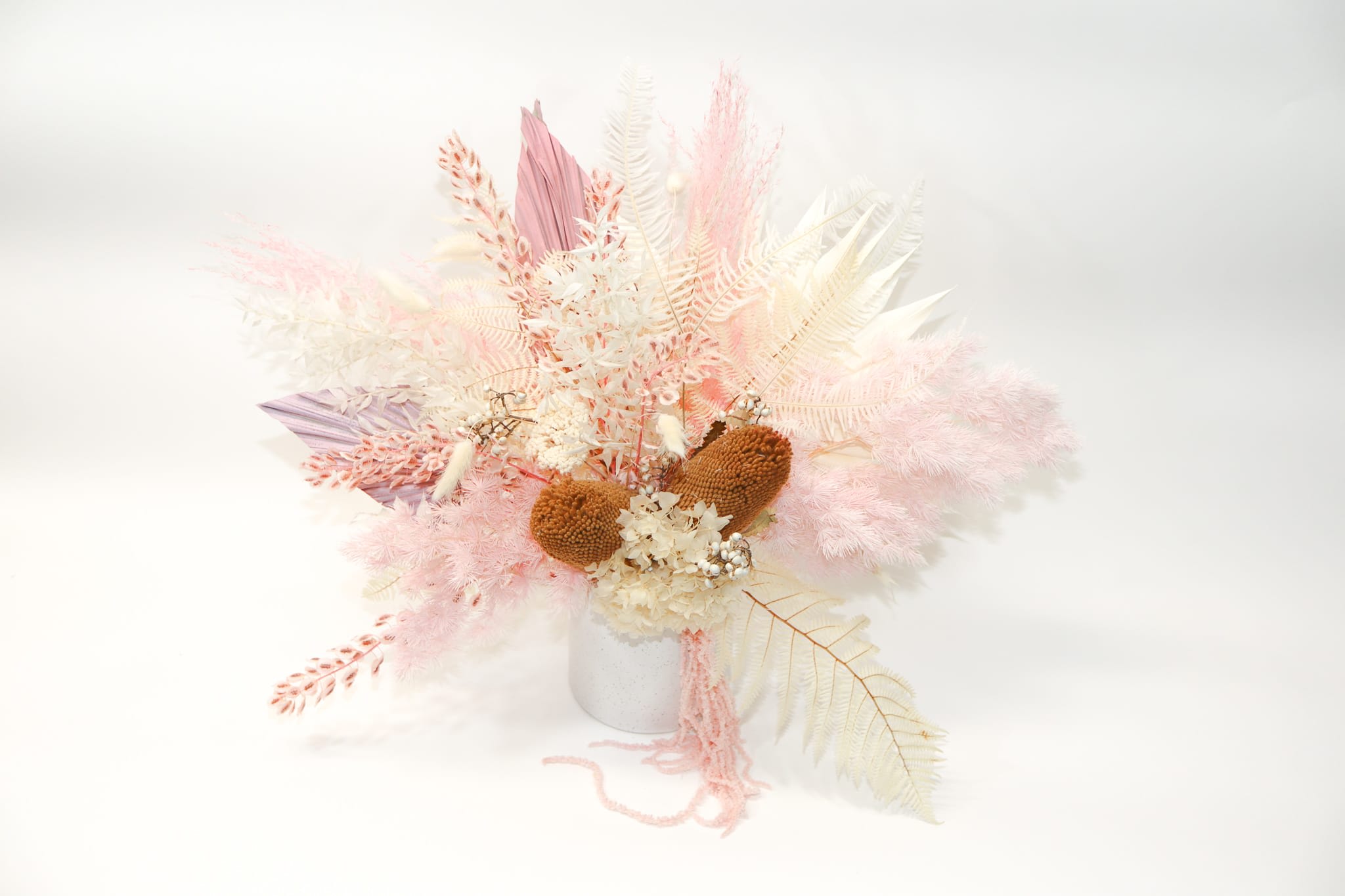 Pastel dried floral arrangement in a white vase