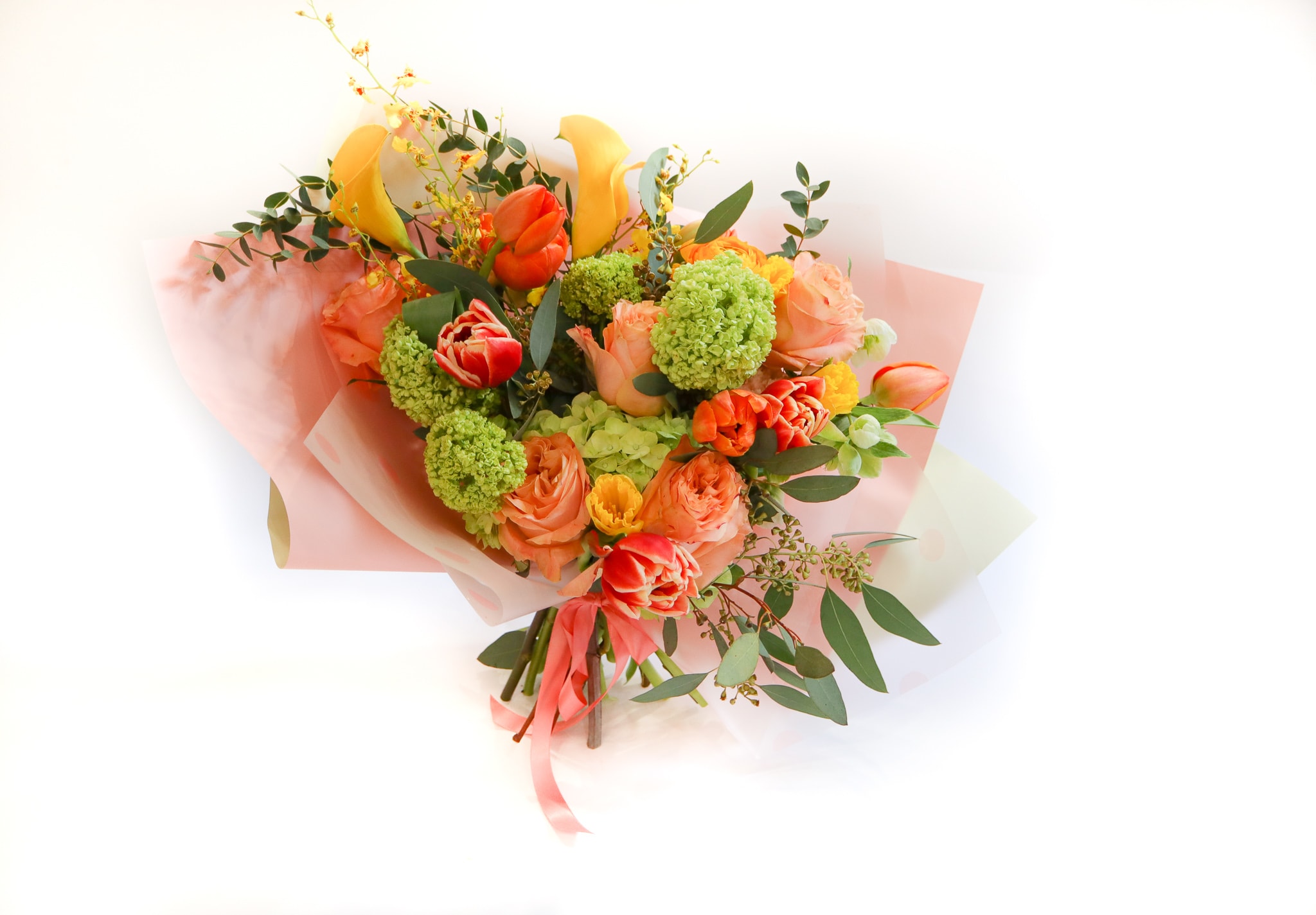 Bouquet of orange and yellow flowers wrapped in pink paper