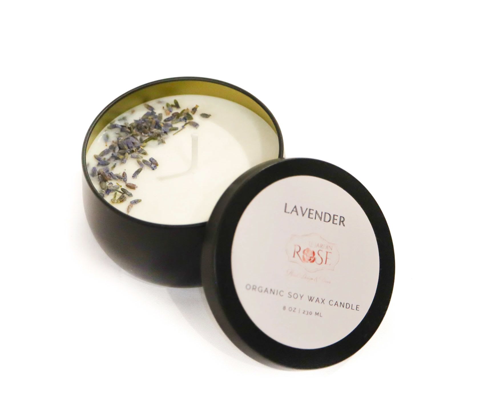 Two black tins of lavender soy wax candles, one open with dried petals on top