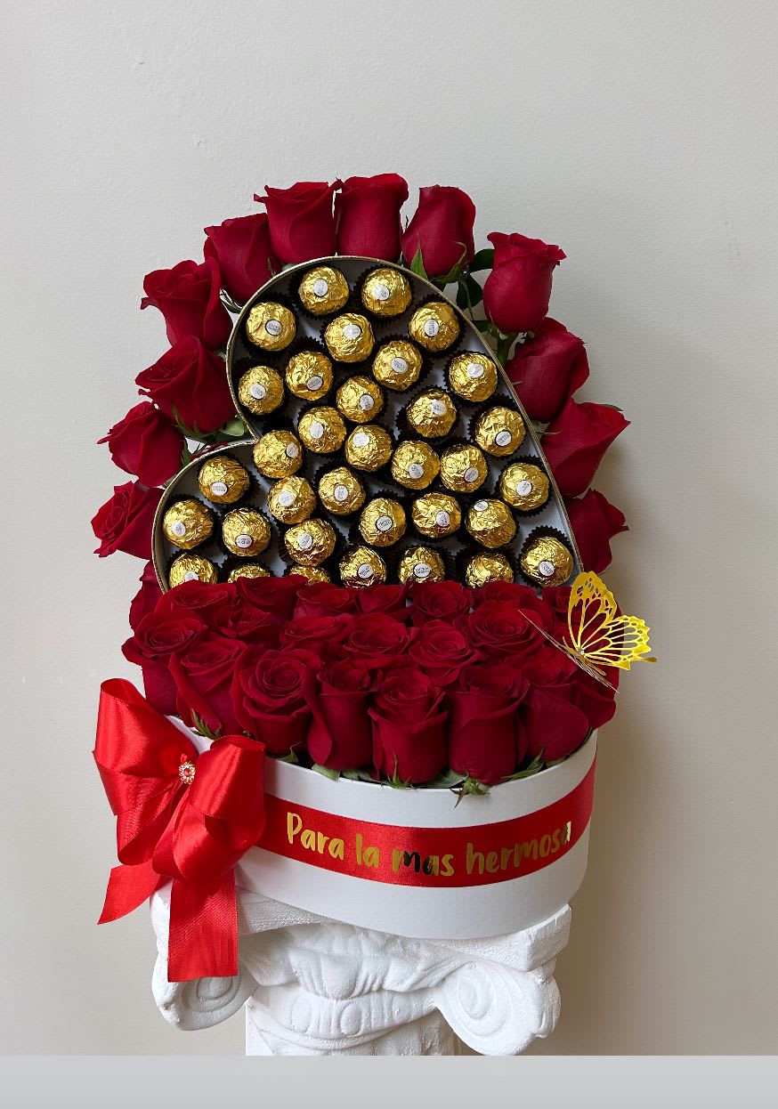 Red roses arranged around a heart-shaped box of chocolates