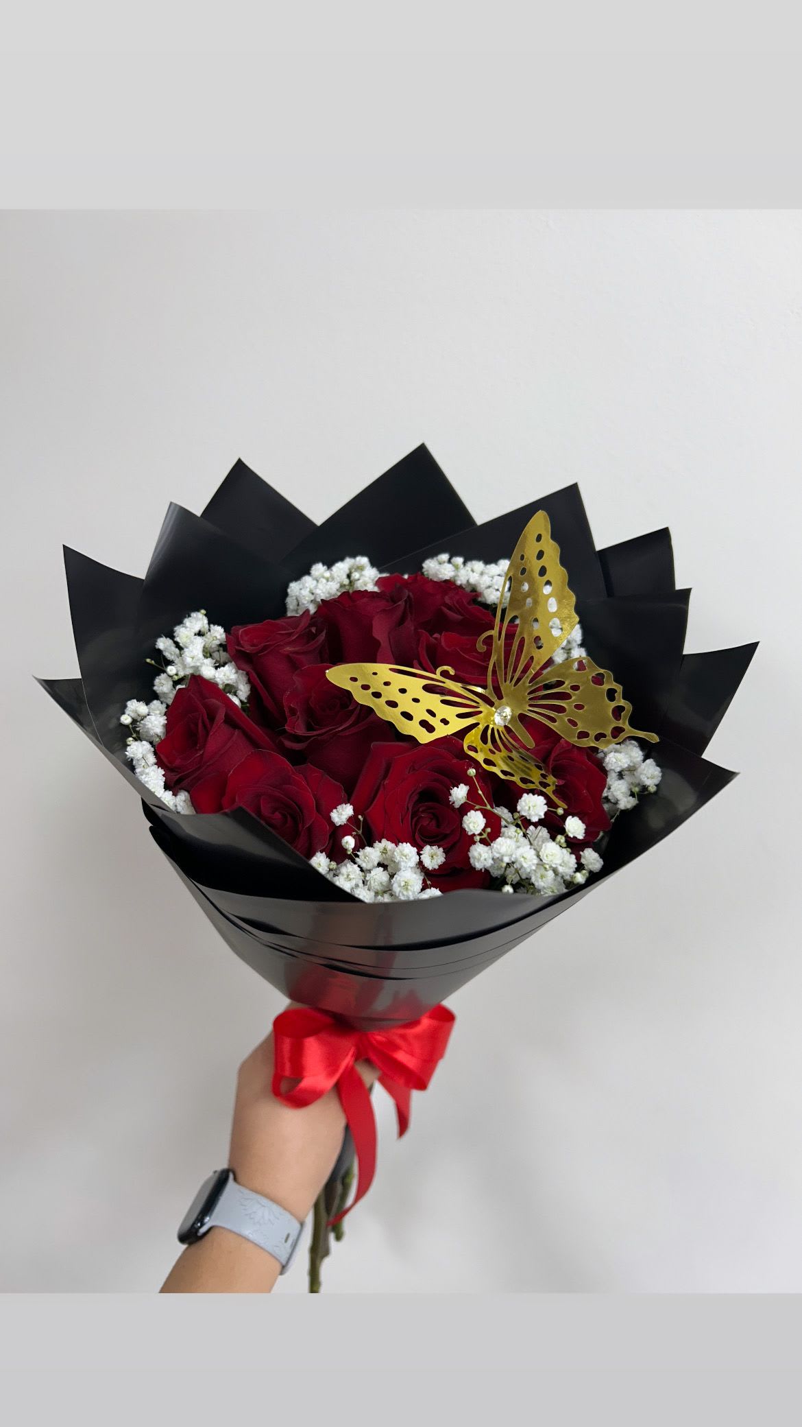 Bouquet of red roses with white baby's breath and a gold butterfly accent