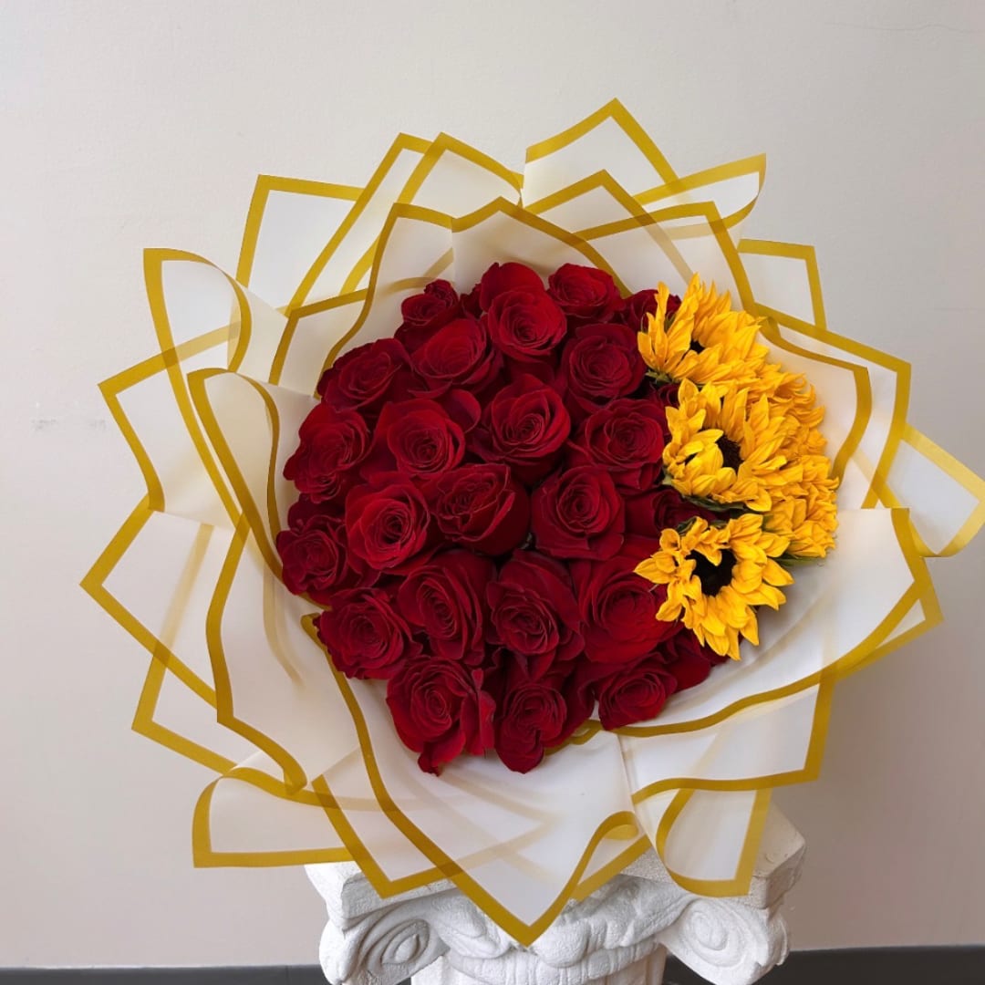 Bouquet of red roses with yellow flowers wrapped in white and gold paper