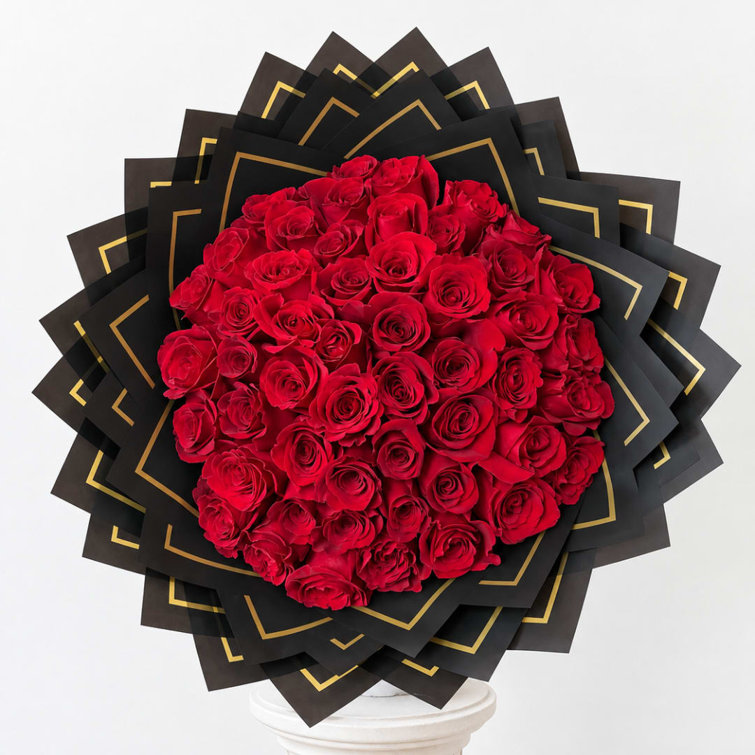 Large bouquet of red roses wrapped in black paper with gold trim