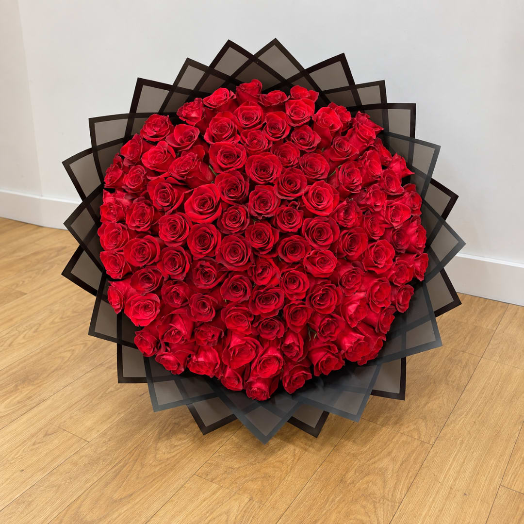 Large bouquet of red roses wrapped in black paper