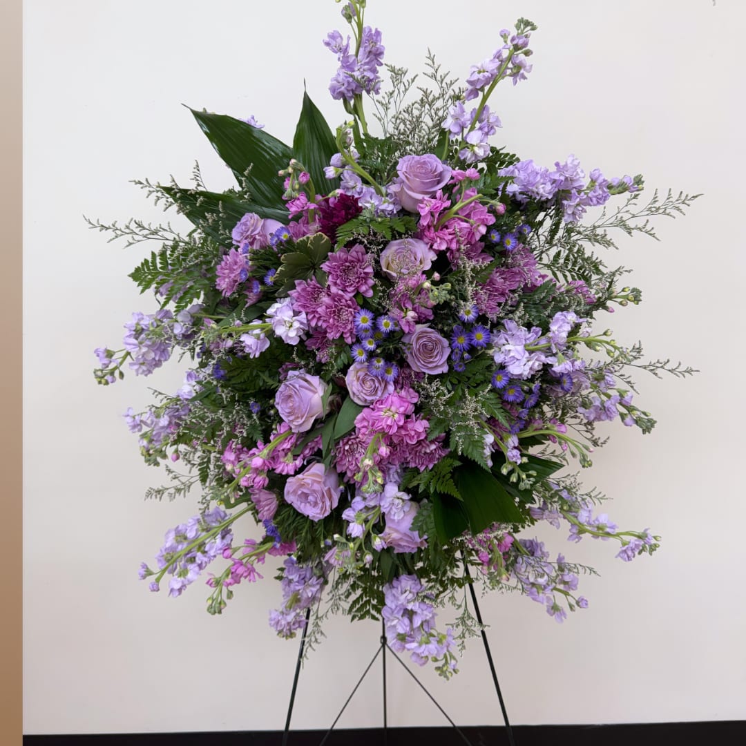 Lavender and pink floral standing arrangement on a black easel