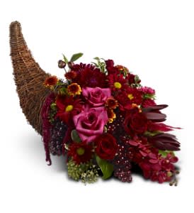 Red and burgundy floral cornucopia arrangement in a wicker horn basket