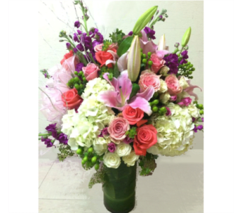 Mixed bouquet of pink, white, and purple flowers in a tall vase