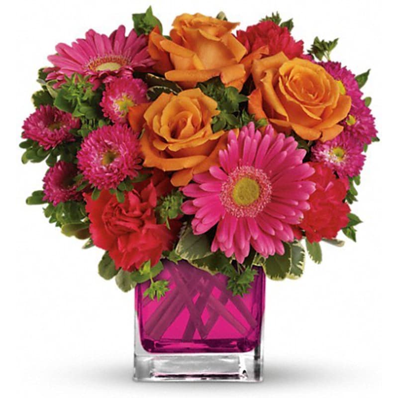 Bouquet of orange roses and pink daisies in a magenta glass vase