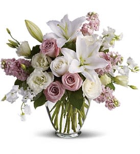 Bouquet of white lilies and pink roses in a clear glass vase