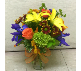 Colorful mixed bouquet in a clear glass vase with a ribbon bow
