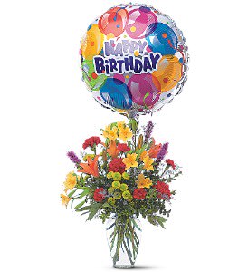Birthday balloon above a colorful mixed flower arrangement in a vase