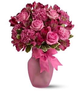 Pink rose and carnation bouquet in a pink vase with ribbon