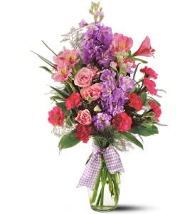 Mixed pink and purple bouquet in a glass vase with a gingham ribbon