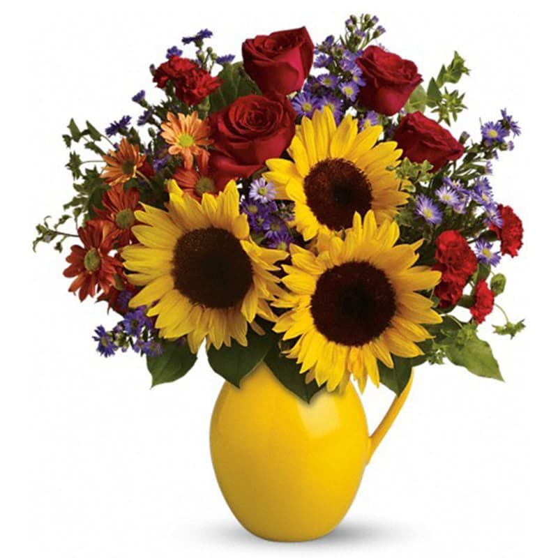 Bouquet of sunflowers, red roses, and mixed daisies in a yellow vase