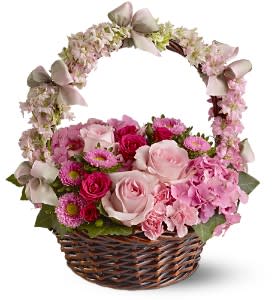 Pink rose and mixed flower basket with floral-covered handle and satin bows