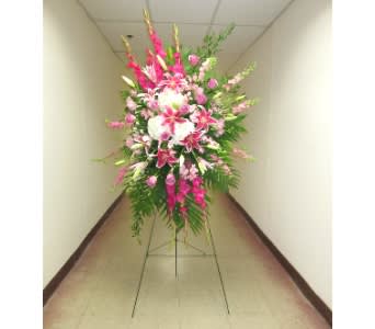 Tall pink and white standing spray with lilies and roses on a metal easel.