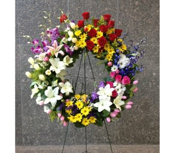 Large multicolor standing wreath of mixed flowers on a metal easel