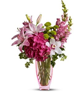 Pink and white floral arrangement in a pink glass vase