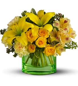 Yellow lilies and roses arranged in a green glass vase