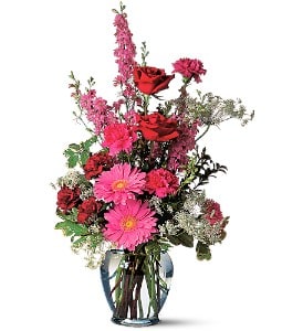 Tall bouquet of pink and red flowers in a clear glass vase