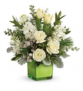 White roses and pale yellow tulips in a green square vase