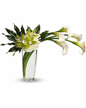 White calla lilies and green orchids in a clear glass vase