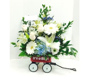 White floral arrangement in a red wagon with wheels