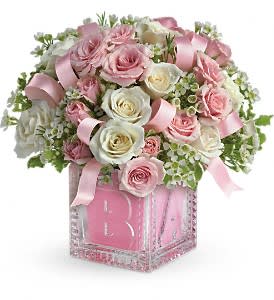 Pink and white rose arrangement in a jeweled vase with ribbon