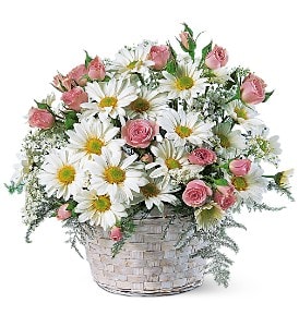 Pink roses and white daisies in a woven basket