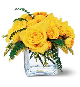 Yellow roses arranged in a clear square vase
