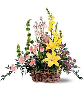 Basket arrangement with yellow lilies, pink flowers, and purple blooms