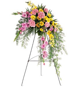 Tall standing spray of pink and yellow flowers on a black metal easel