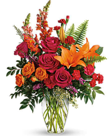 Bright mixed bouquet with roses and lilies in a glass vase