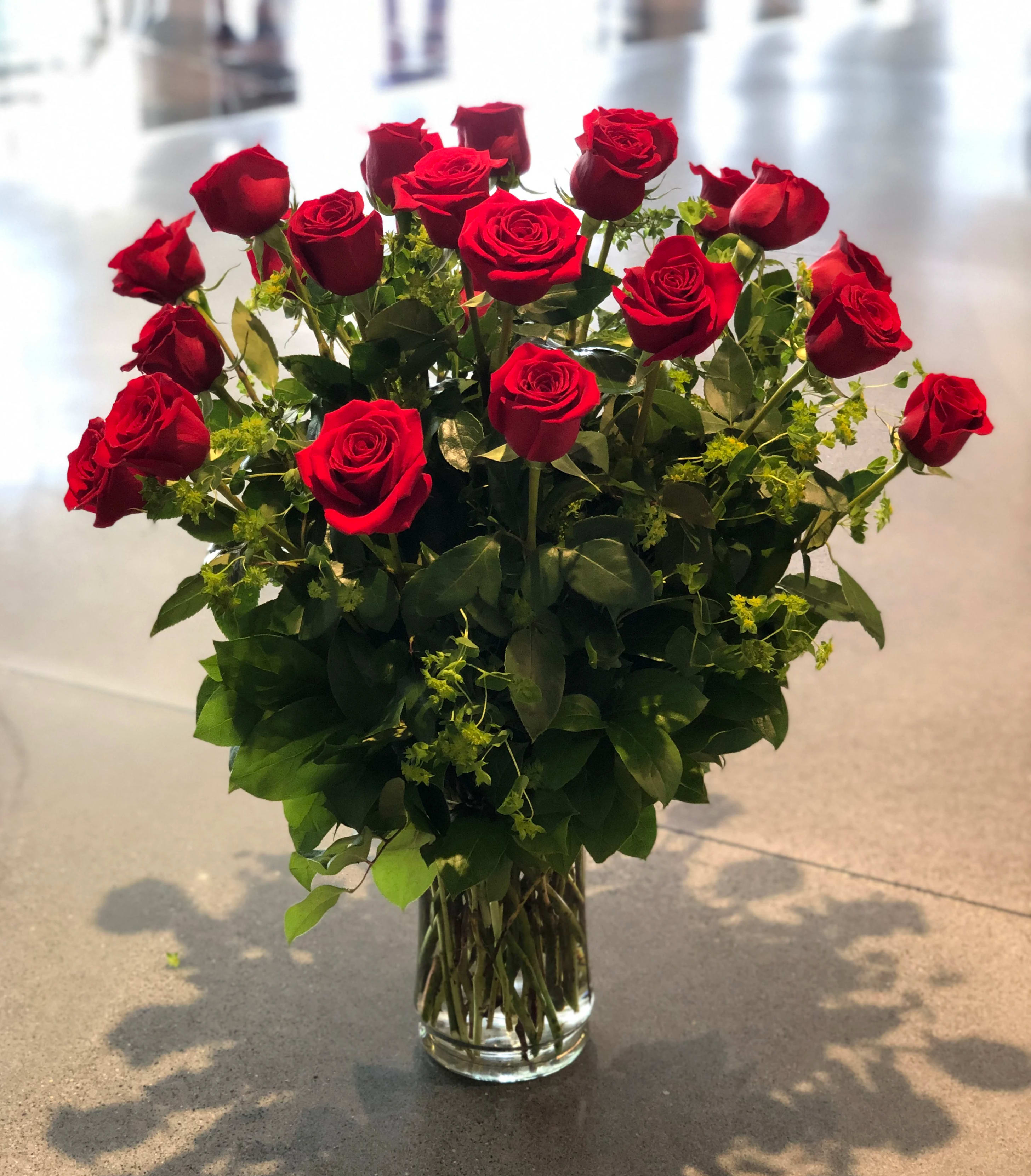 Red roses arranged in a clear glass vase