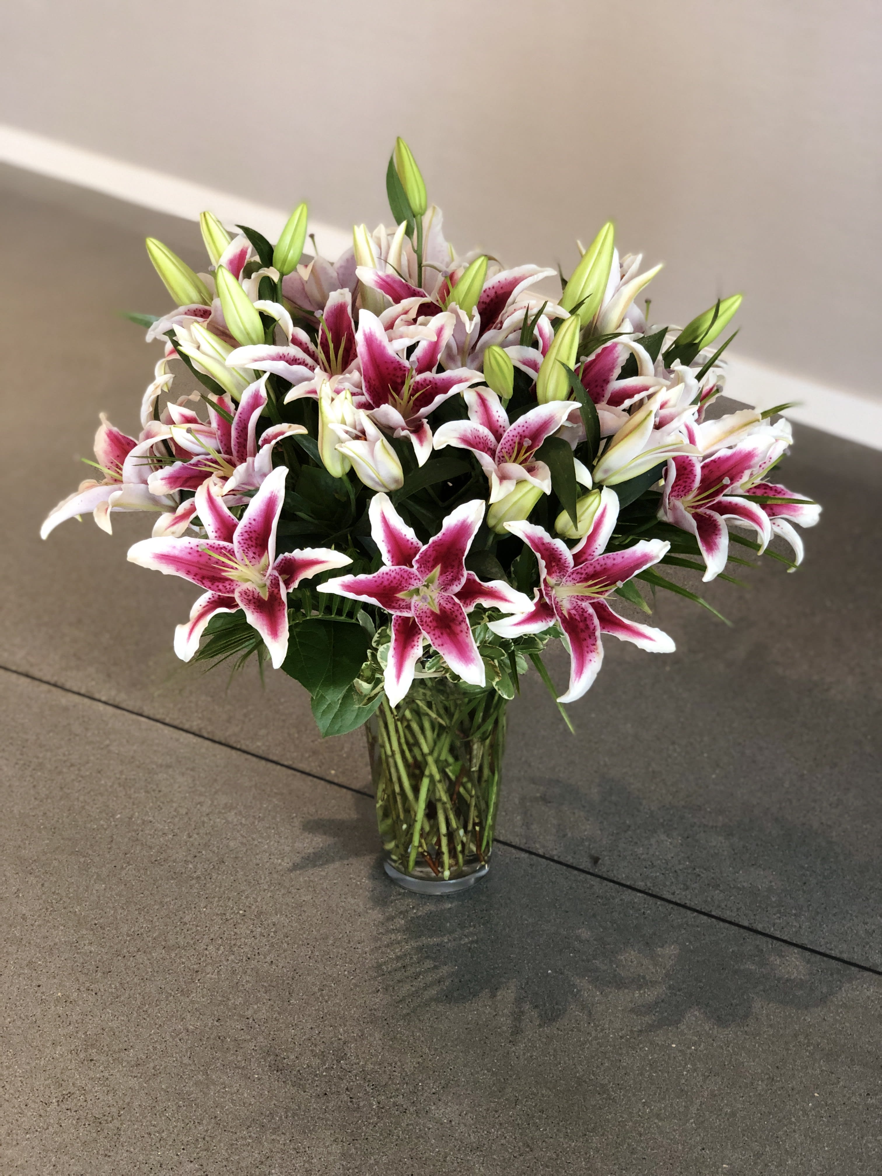 Bouquet of pink and white lilies in a clear glass vase