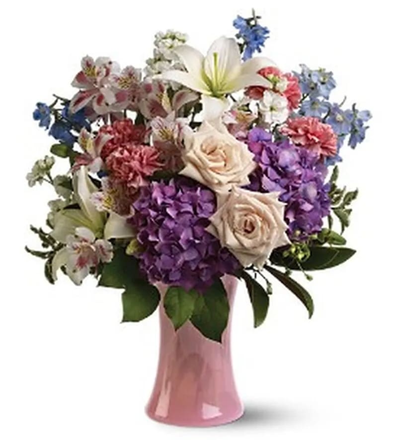Mixed bouquet of roses, lilies, hydrangeas, and alstroemeria in a pink vase