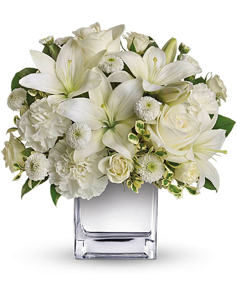 White lilies and roses arranged in a clear glass vase