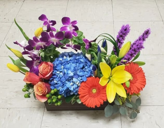 Colorful floral arrangement in a rectangular wooden container