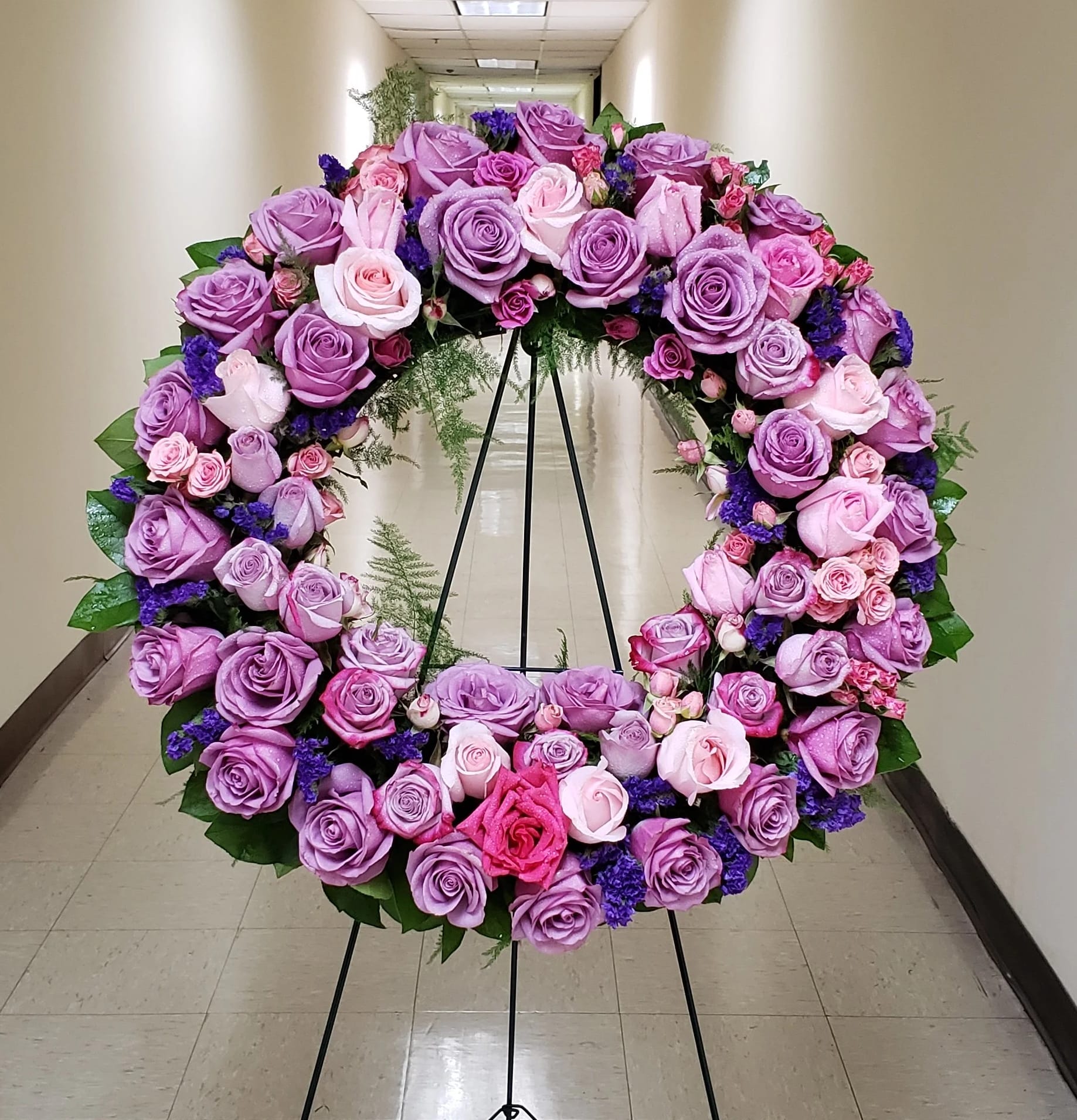 Standing wreath of lavender and pink roses on a black easel