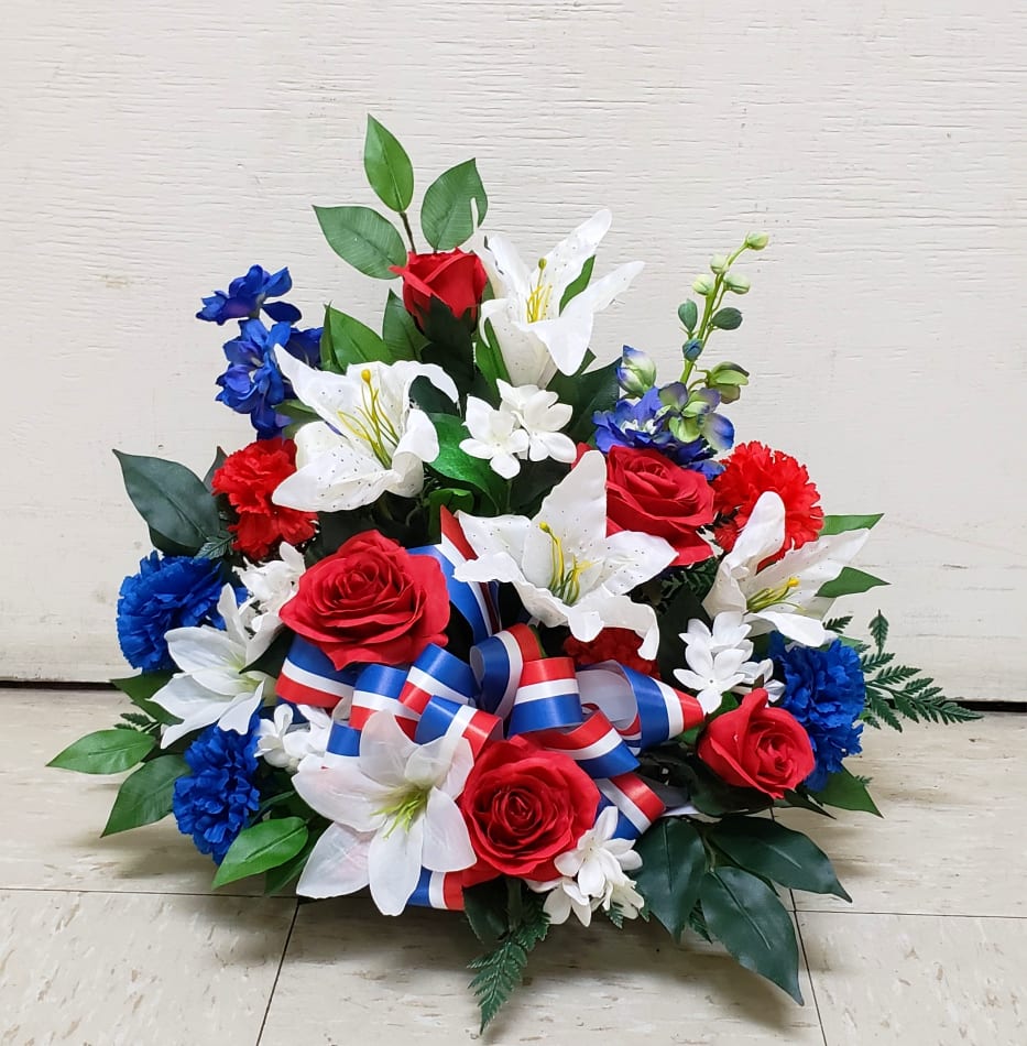 Red, white, and blue silk arrangement with roses, lilies, and carnations with patriotic ribbon in a low container